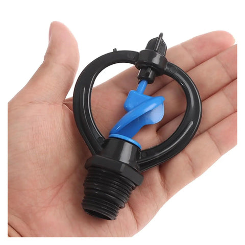Hand holding 360 Degree Garden Sprinkler Nozzle For Lawn And Garden 1/2 Inch To 3/4 Inch Rotary Irrigation Sprayer with blue nozzle tubes