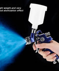 Heavy-Duty 0.8mm Pneumatic Airbrush With 125ml Gravity Feed Cup spraying fine mist for auto body and furniture projects.