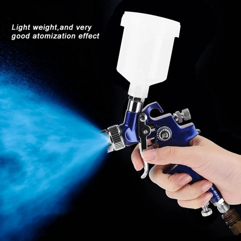Heavy-Duty 0.8mm Pneumatic Airbrush With 125ml Gravity Feed Cup spraying fine mist for auto body and furniture projects.