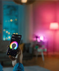 Person using app to control Crazy Bright Supercolor BR30 Smart Flood Bulbs 2 Pack RGB Plus Tunable White in living room ambiance