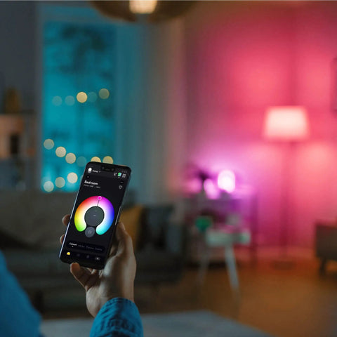 Person using app to control Crazy Bright Supercolor BR30 Smart Flood Bulbs 2 Pack RGB Plus Tunable White in living room ambiance