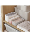 Four Piece Plastic Drawer Organizer Box With Compartment Dividers For Bras Underwear And Socks Nifty Closet Storage Bins on wooden shelf.