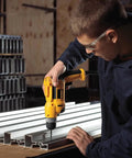 Person using Corded Drill Beast With 8 Amp Motor, 0-2,500 RPM, 3/8 Inch Keyless Chuck, Pistol Grip, in workshop on metal tracks.