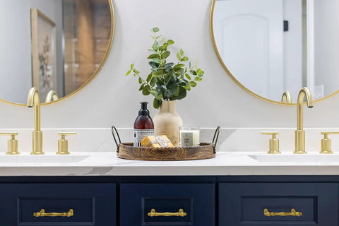 Rad Five Inch Brushed Gold Cabinet Pulls And Drawer Handles on blue cabinetry in an elegant bathroom setting.