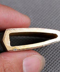 Close-up of a Premium Brass Habaki Collar Clip for Katana Swords held between fingers showing the interior angle