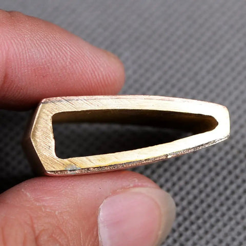 Close-up of a Premium Brass Habaki Collar Clip for Katana Swords held between fingers showing the interior angle