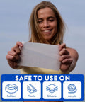 Hearing aid cleaning wipe held by woman; white towelette with rubber, plastic, silicone, acrylic icons.