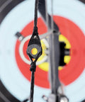Lightweight Rubber Peephole Tube Replacement for Compound Bow String Systems attached to bowstring with target background