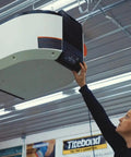 User interacting with Air Filtration System With Auto Sensor And Six Speed Control For Boss Level Air Quality Captures 99 Percent Of 5 Micron Particles And 85 Percent Of 1 Micron Particles Delivers Up To 1000 CFM At 120V Single Phase mounted in workshop ceiling