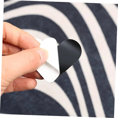 Hand holding a piece of Heart Shaped Rug Tape Set 8 Pcs No Fuss Non Slip Double Sided Stickers For Area Rugs And Carpets Easy Install No Residue
