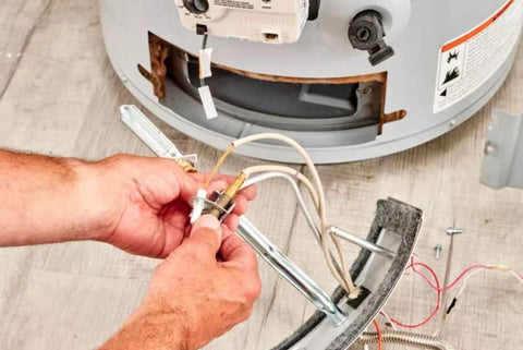 Close-up of hands installing a 30-inch replacement thermocouple for gas furnaces, boilers and water heaters