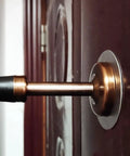 Zero Hassle Wall Mount Door Stopper showing brushed stainless steel frame with black rubber bumper on a door.