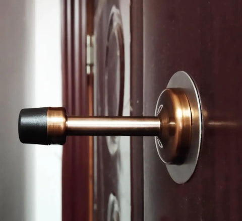 Zero Hassle Wall Mount Door Stopper showing brushed stainless steel frame with black rubber bumper on a door.