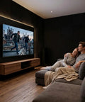 Couple enjoying a movie on a large screen surrounded by 52 Piece Black Acoustic Foam Wall Panels With Heavy Duty Mounting Tape.