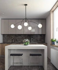 Matt Black Sputnik Chandelier Five Light Pendant hanging over modern kitchen island with stools, grey cabinets, and green decor.