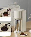 Automatic Coffee Maker With Built In Grinder Compact Portable Insulated Cup on a kitchen table, showing coffee beans and grounds.