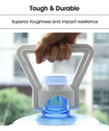Person holding a durable water jug with strong handle, showcasing impact resistance, with a building exterior background