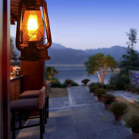 Pack Of 2 Vintage Rustic Lantern Lamps With Edison LED Bulbs, Bronze Rust Finish, hanging in outdoor setting near bar area.
