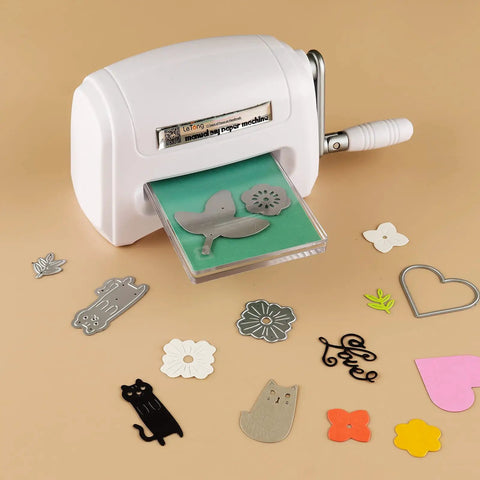 Portable Manual Die Cutting And Embossing Machine For DIY Crafting with paper die cuts on beige surface