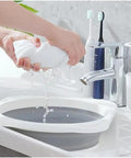 Person squeezing a towel over Road Trip Ready Lightweight Folding Wash Basin One Point Four Gallon Capacity No Fuss Bpa Free Plastic soaking tub.