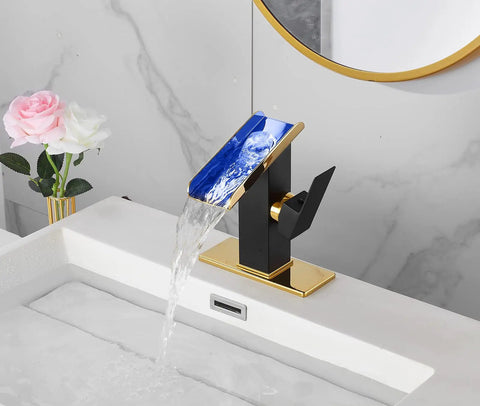 Super Dope Black And Gold Brass Single Handle Rgb Led Waterfall Bathroom Faucet With Color Changing Lights Using Hydropower No Battery Temperature Sensing For Your Cool Modern Vanity Sink Lavatory Tap in use with blue light flowing water over white sink