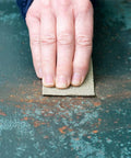 Hand using Heavy Duty 100 Grit Multi Purpose Sandpaper Sheets 9 By 11 Inch Pack Of 25 Do It All For Sanding Metal Wood And Painted Surfaces