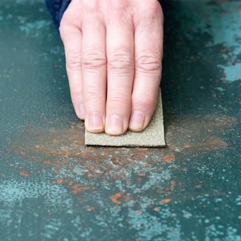Hand using Heavy Duty 100 Grit Multi Purpose Sandpaper Sheets 9 By 11 Inch Pack Of 25 Do It All For Sanding Metal Wood And Painted Surfaces