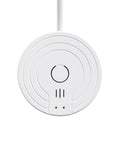 White circular alarm sensor with central button, concentric ring design, vent slots and green/red LEDs, front view