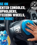 Hand using Sticky Icky Car Cleaning Gel With Green Apple And Strawberry Scent Fast Detailing Kit on steering wheel in car