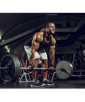 Man at gym lifting barbell using Weightlifting Straps With Cotton Pads For Strong Grip And Wrist Wraps For Dumbbell And Barbell Training.