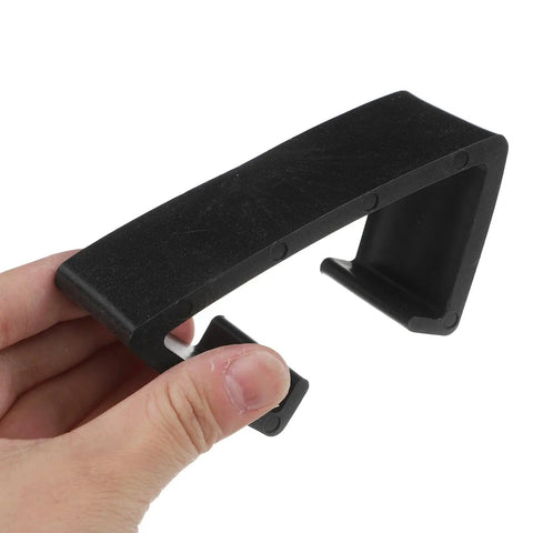 Close-up of a hand holding a black clip from 4 Pack Outdoor Furniture Clips For Wicker Sectional Sofas And Rattan Chairs Black 90mm Inner Diameter Easy Clip Fasteners For Seamless Sectional Alignment And No Fuss Outdoor Lounge Sets