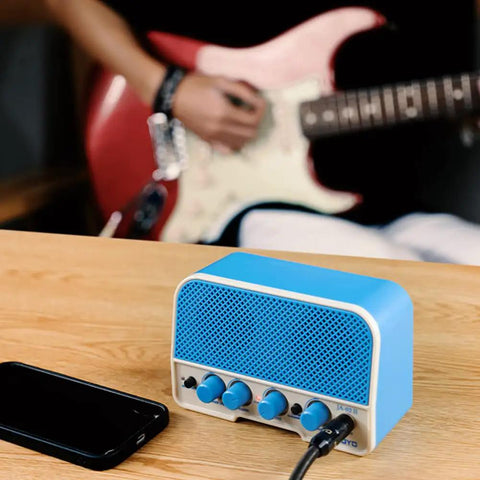 Tiny But Mighty 5W Mini Guitar Amp With Bluetooth 5.0, Clean And Overdrive Channels, Rechargeable Battery, Blue Edition on desk