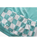 Close-up of teal and white checkered fabric design on a garment showing pockets and stitching details