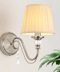 1-Light Brushed Nickel Vanity Light with Beige Fabric, Modern Wall Sconce, showcasing a curved arm and decorative crystals.