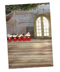 Holiday decorative setup with plush toys in red boots and a wooden door, set against a textured wall background.
