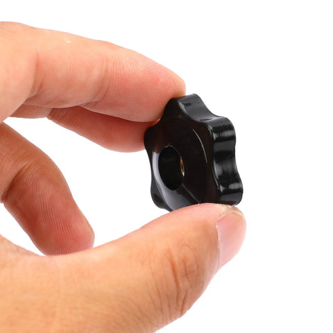 Six-star black clamping knob with 1/4-20 female thread, held between fingers