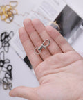 Hella Durable Premium Silver Swivel Snap Hooks 50 Pack Lobster Claw Trigger Clasps shown in hand for keychains and lanyards.