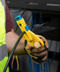 Person using Data And Coax Cable Stripping Tool With Radial Design For RG59 RG6 And CAT3 To CAT6A on black cable wearing gloves.