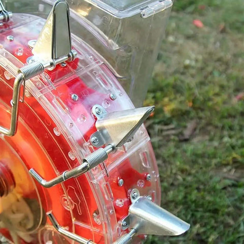 Close-up of Metal Precision Garden Push Seeder wheel with clear seed storage box, showing metal spring parts for easy sowing.