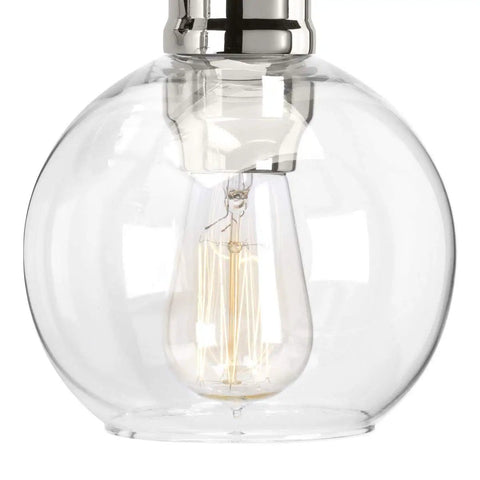 Close-up of a clear glass globe shade and bulb from the Hansford 4 Light Bath Vanity Fixture In Polished Nickel With Glass Globe Shades For Urban Industrial Vibe Bathroom Lighting In A Modern Master Bath Perfect For Contemporary Bathrooms