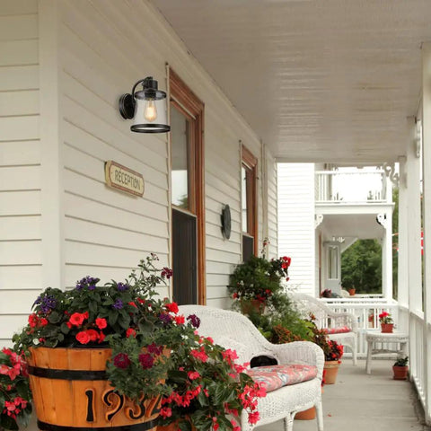 Oil Rubbed Bronze Outdoor Indoor Wall Sconce With Seeded Glass Shade on porch with flowers and white wicker chairs