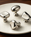 Four polished chrome knobs on a plate, including a Titanium Silver Mushroom Cabinet Knobs 1.28 Inch Round Zinc Alloy Drawer Knob.