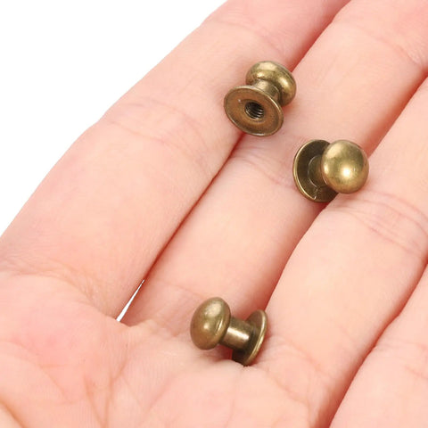 Slick 50 Pack Mini Round Knobs In Sweet Black Zinc Alloy, Hella Sturdy 7mm Drawer Pulls displayed in hand.