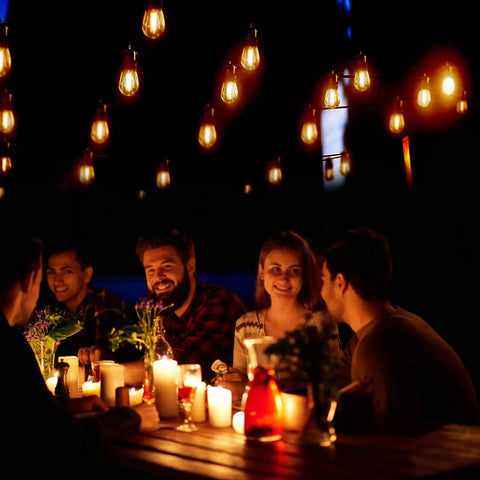 Shatterproof LED Outdoor String Lights 48Ft IP65 Waterproof Edison Vintage lights illuminating a group dining outdoors.