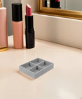 Velvet Jewelry Organizer Tray With Four Grid Compartments Stackable Minimalist design on tabletop beside cosmetics.
