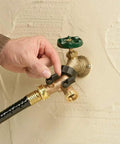 Heavy Duty Brass Dual Outlet Faucet Adapter Lets You Split One Faucet Into Two Hose Outlets With Separate Ball Valve Levers For Easy Flow Control Durable Brass Construction Handles High Water Pressure Brown Finish installed on outdoor wall with hose attached