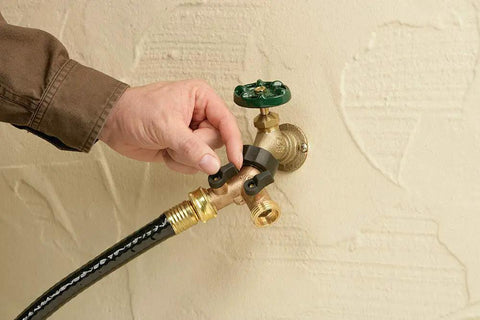 Heavy Duty Brass Dual Outlet Faucet Adapter Lets You Split One Faucet Into Two Hose Outlets With Separate Ball Valve Levers For Easy Flow Control Durable Brass Construction Handles High Water Pressure Brown Finish installed on outdoor wall with hose attached