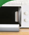 Roll of pro grade vacuum sealer wrap in front of a microwave, highlighting BPA free commercial grade material for sous vide cooking.