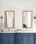 Mid Century Modern Gold Crystal Wall Sconce Set Of Two in bathroom with blue cabinets, brushed brass tube lighting, clear glass shades