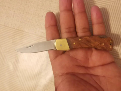 Handmade Folding Pocket Knife With Rosewood Handle And Brass Bolsters in hand, 2.2 inch stainless blade, 3 inch closed length
